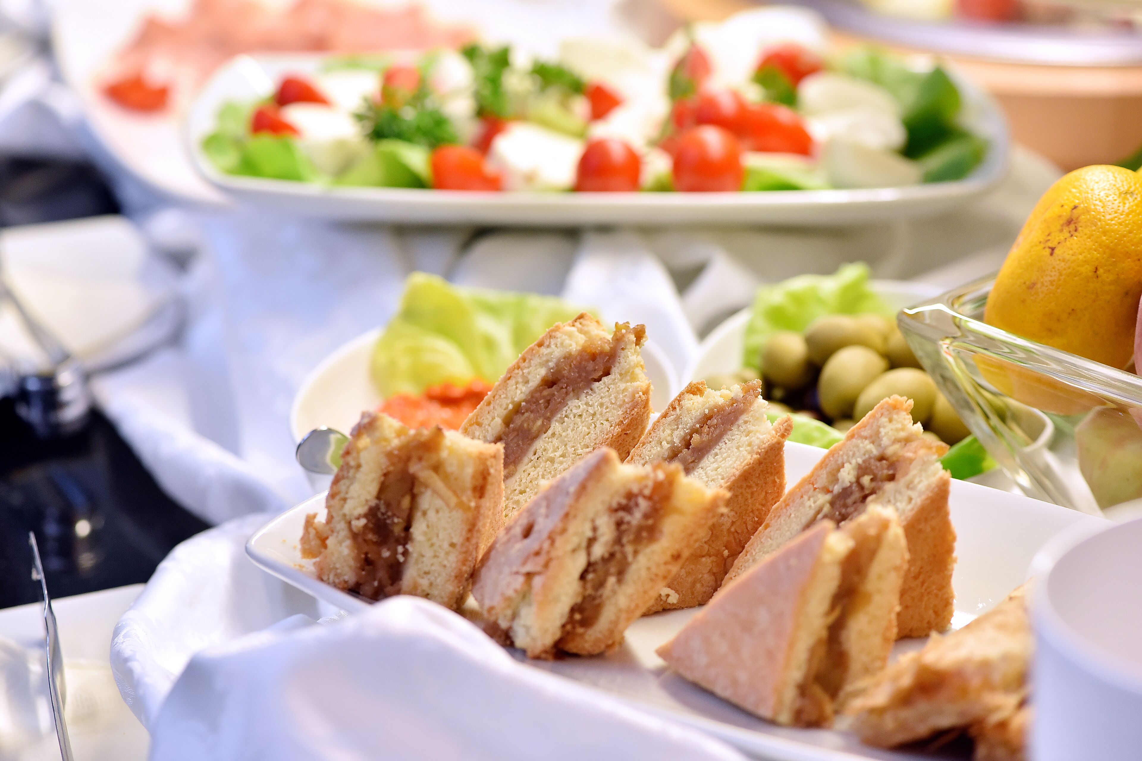 A table with various food items including sliced bread, olives, and a lemon.