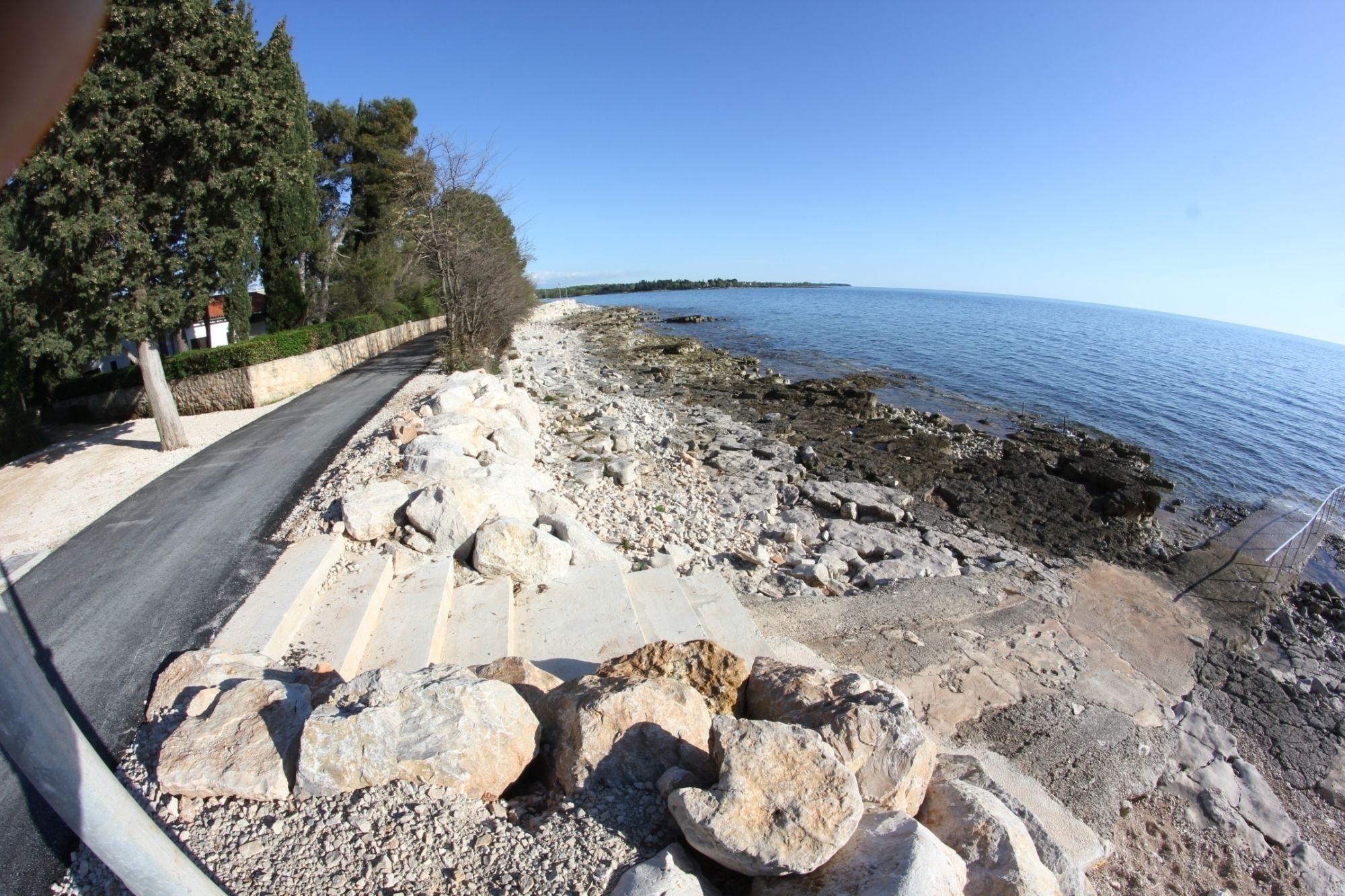 Eine Küstenstraße mit felsigem Gelände und freiem Blick auf das Meer.