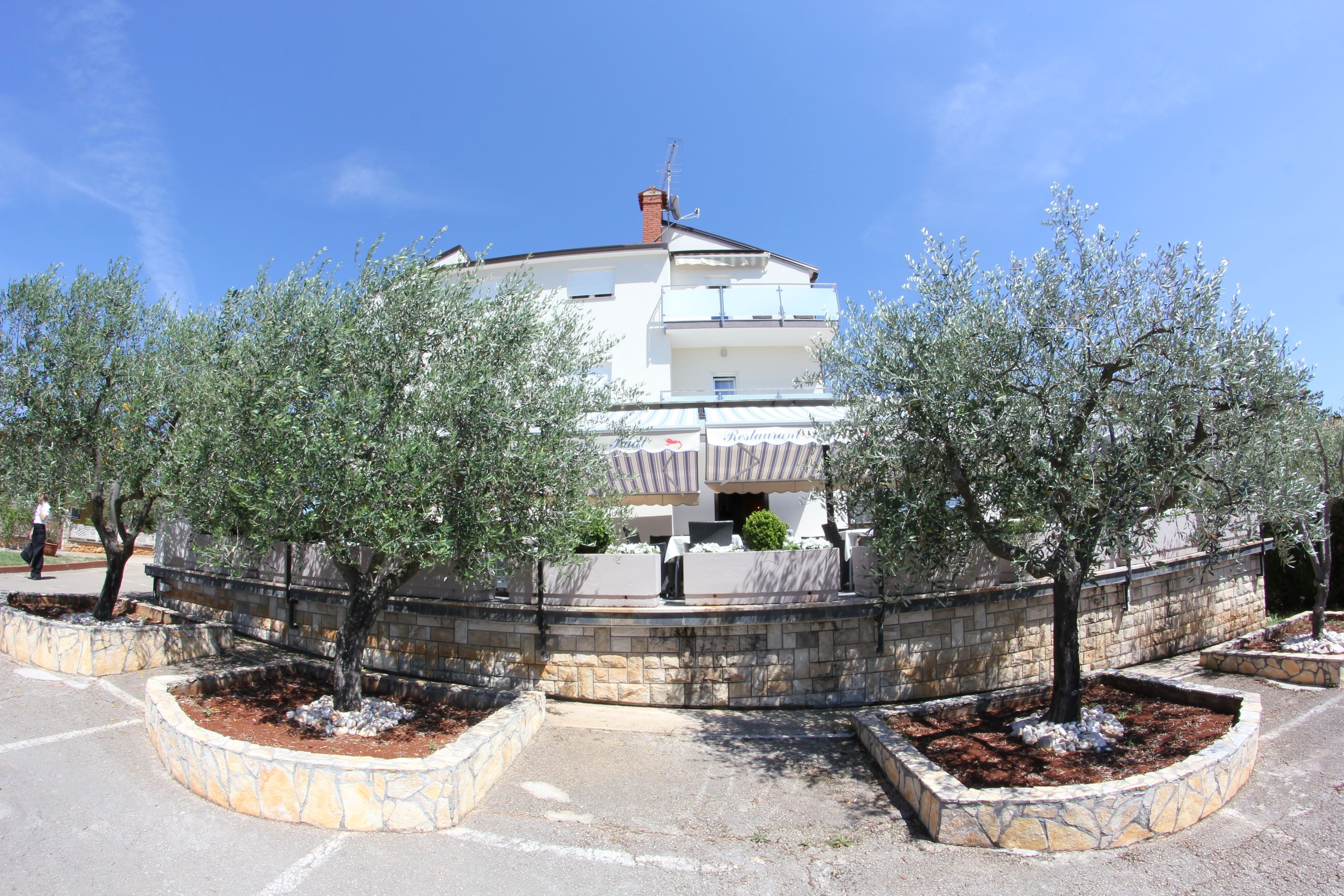 Un bâtiment avec un mur en pierre et des arbres devant.