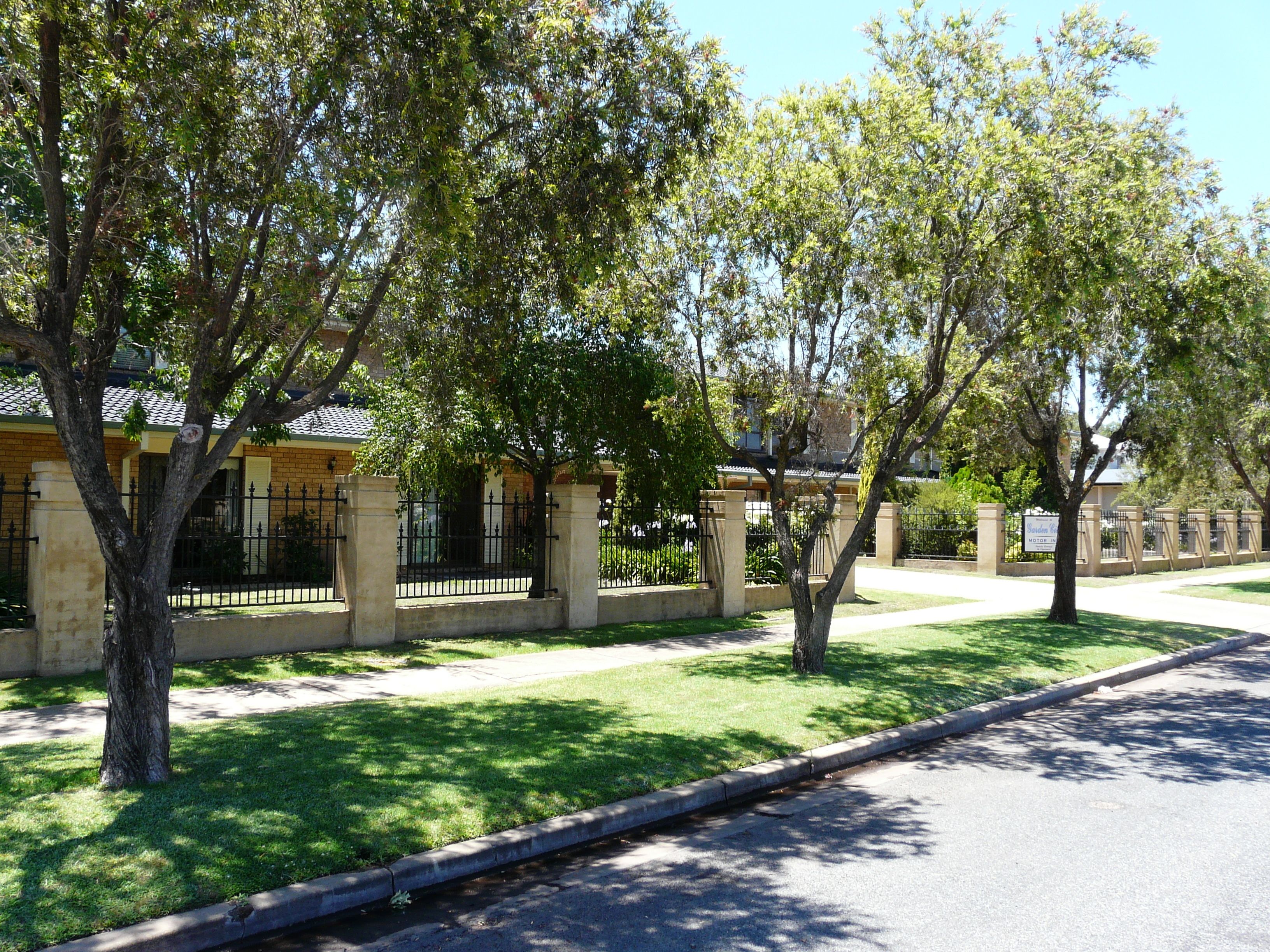 A residential street lined with trees and houses.
