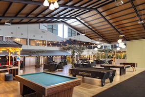 A spacious indoor recreational area with pool tables, seating, and a high ceiling with exposed beams. - Aparthotel Delden (Delden)