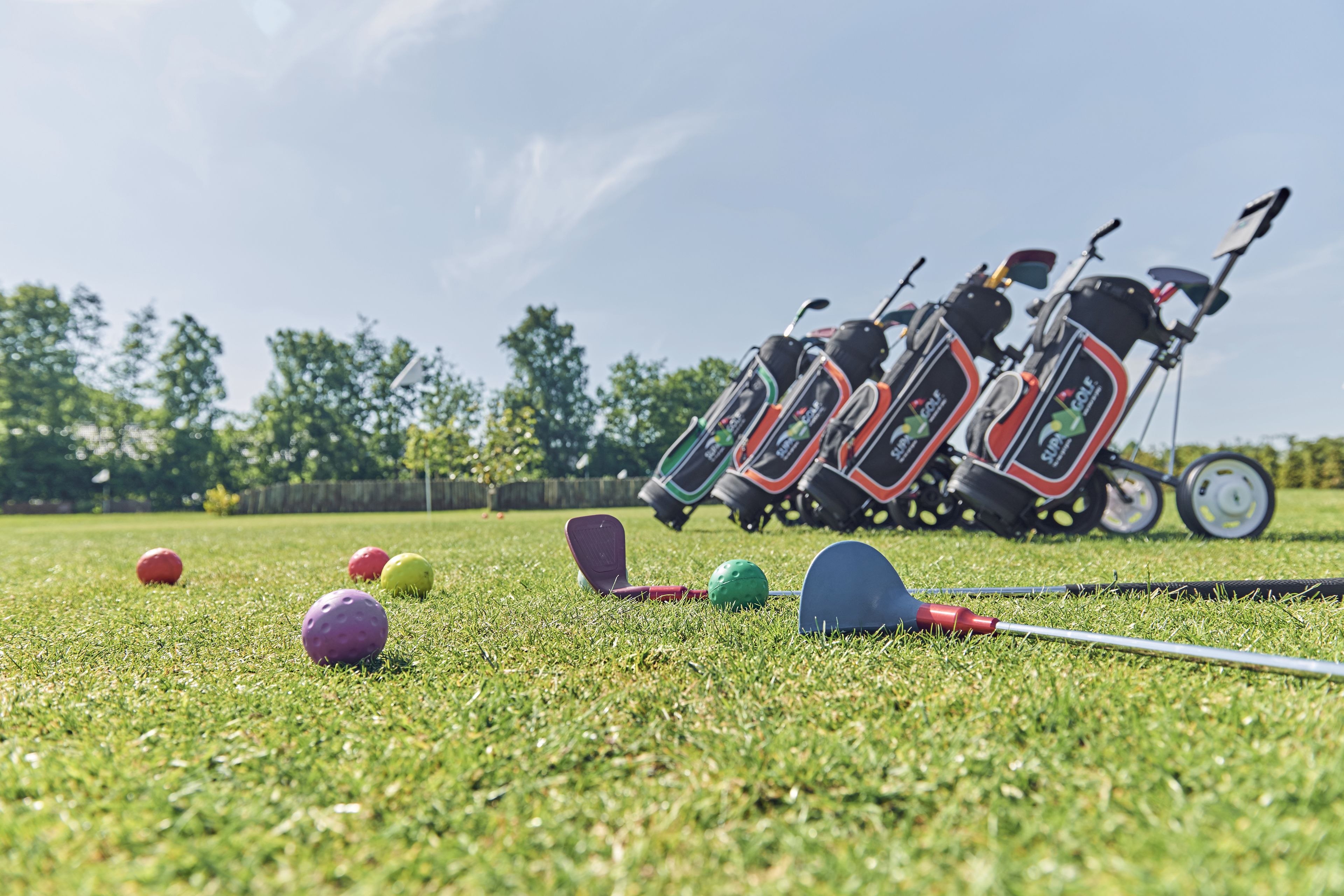 A golf course with a cart and golf balls.