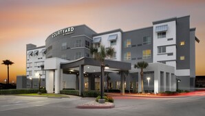 Un hotel Courtyard by Marriott con un diseño moderno, que cuenta con varios pisos y una zona de entrada cubierta.