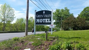 A motel sign with a tree logo, a Wi-Fi open sign, and a daily & weekly rates sign. - Green Valley Motel (Williamstown)