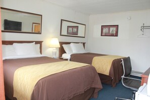 A hotel room with two beds, a desk, a chair, a lamp, and framed pictures on the wall. - Green Valley Motel (Williamstown)