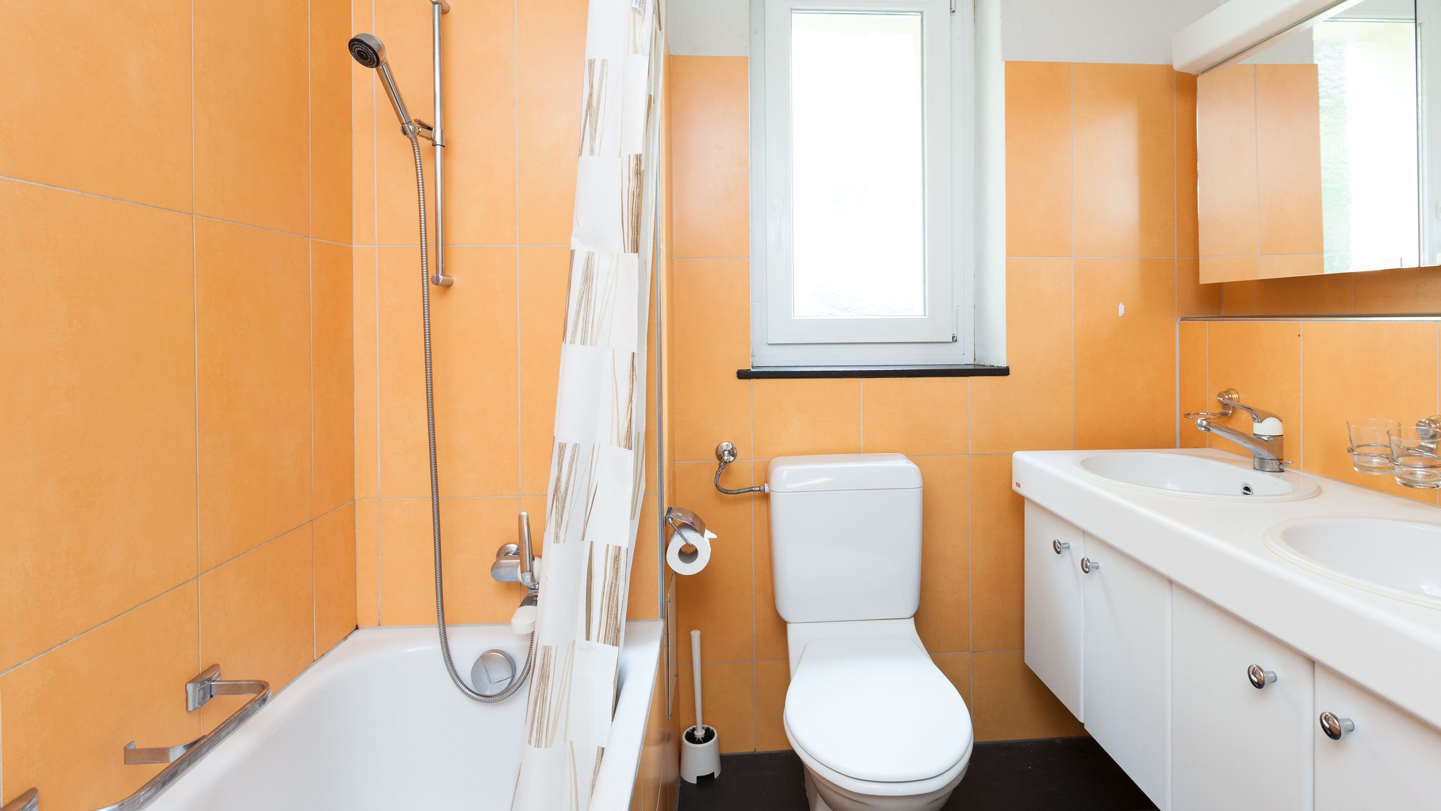 Ein Badezimmer mit einer Badewanne, Toilette und zwei Waschbecken.