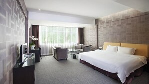 A modern hotel room with a large bed, a desk with a chair, a sofa, and a large window with curtains. - The Art Hotel - Shenzhen (Shenzhen)