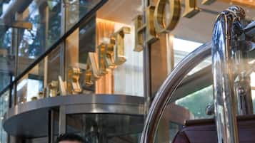 Entrada de un hotel con puerta giratoria y un letrero que dice 'HOTEL'.