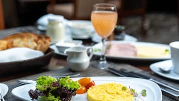 Un desayuno con huevos revueltos, un croissant y un vaso de zumo de naranja.