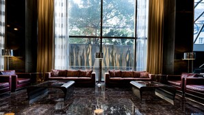 Eine Lobby mit Ledersofas, einem Glastisch und einem Marmorboden.