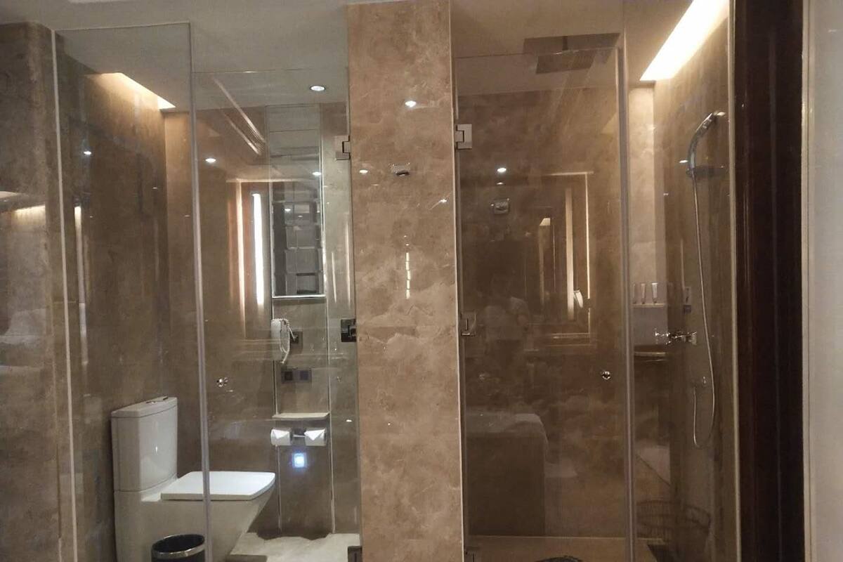 Une salle de bain moderne dotée d’une douche à parois de verre, de toilettes et d’un bidet.