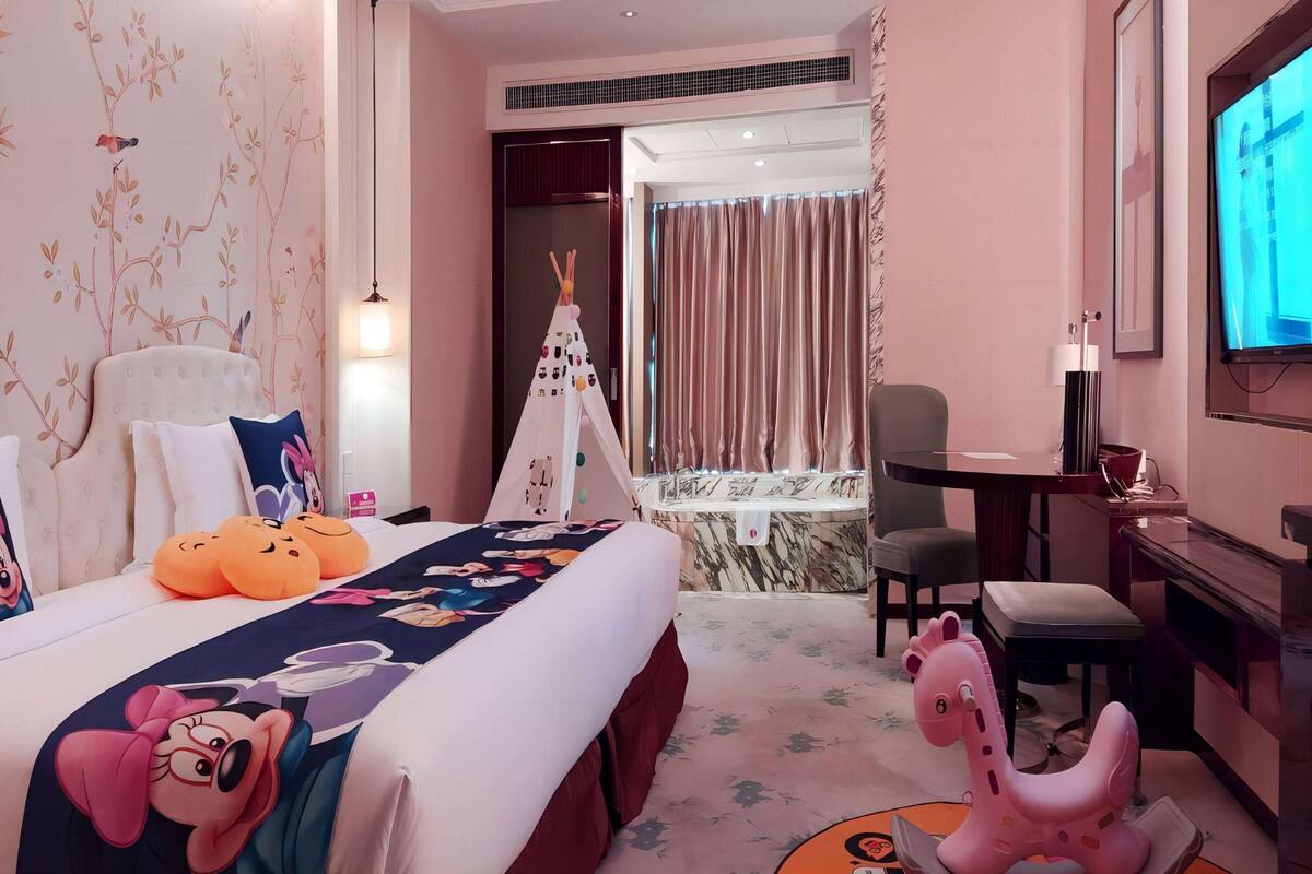 Une chambre d’hôtel équipée d’un lit, d’un bureau, d’une chaise, d  ’une télévision et d’une structure ressemblant à une tente.