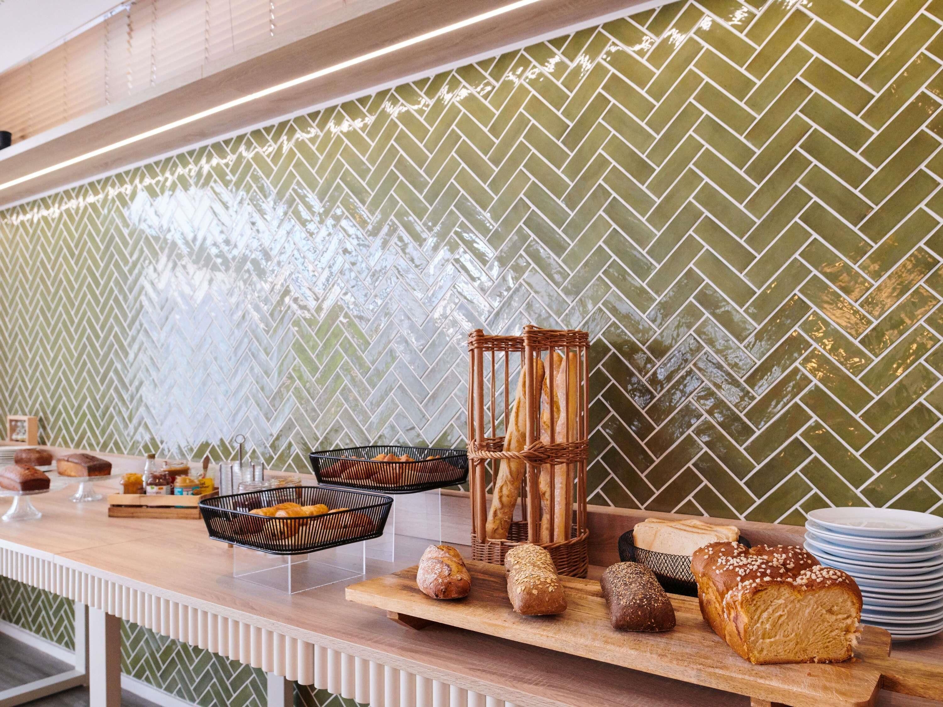 A breakfast bar with bread, pastries, and a wicker basket.