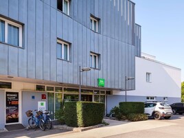 A modern building with a bike parking area and a sign for 'ibis styles'.