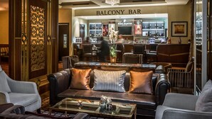 A bar area with a chandelier, leather seating, and a bar counter.