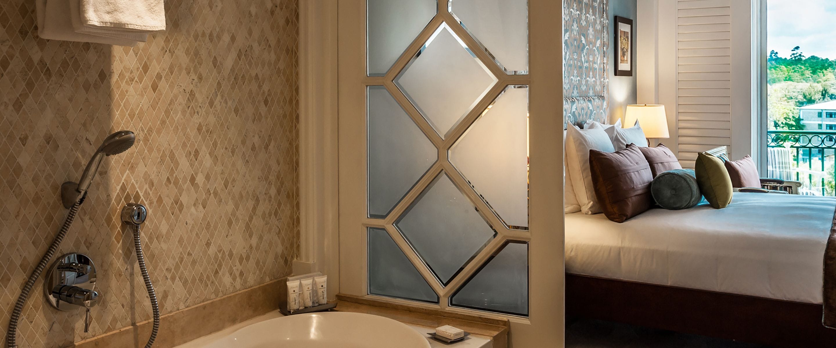 A bathroom with a bathtub, shower, and a decorative wall.