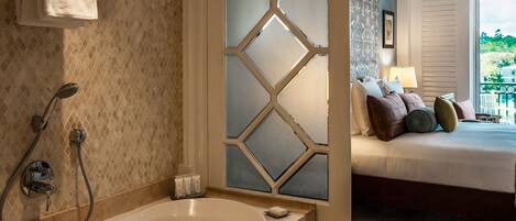 A bathroom with a bathtub, shower, and a decorative wall.