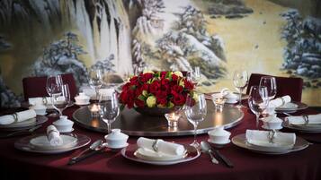 A table set for a formal dinner with a floral centerpiece, white napkins, and wine glasses.