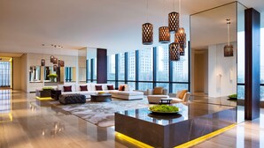 A modern living room with a large sofa, a coffee table, and hanging pendant lights. - Grand Hyatt Shenyang (Shenyang)
