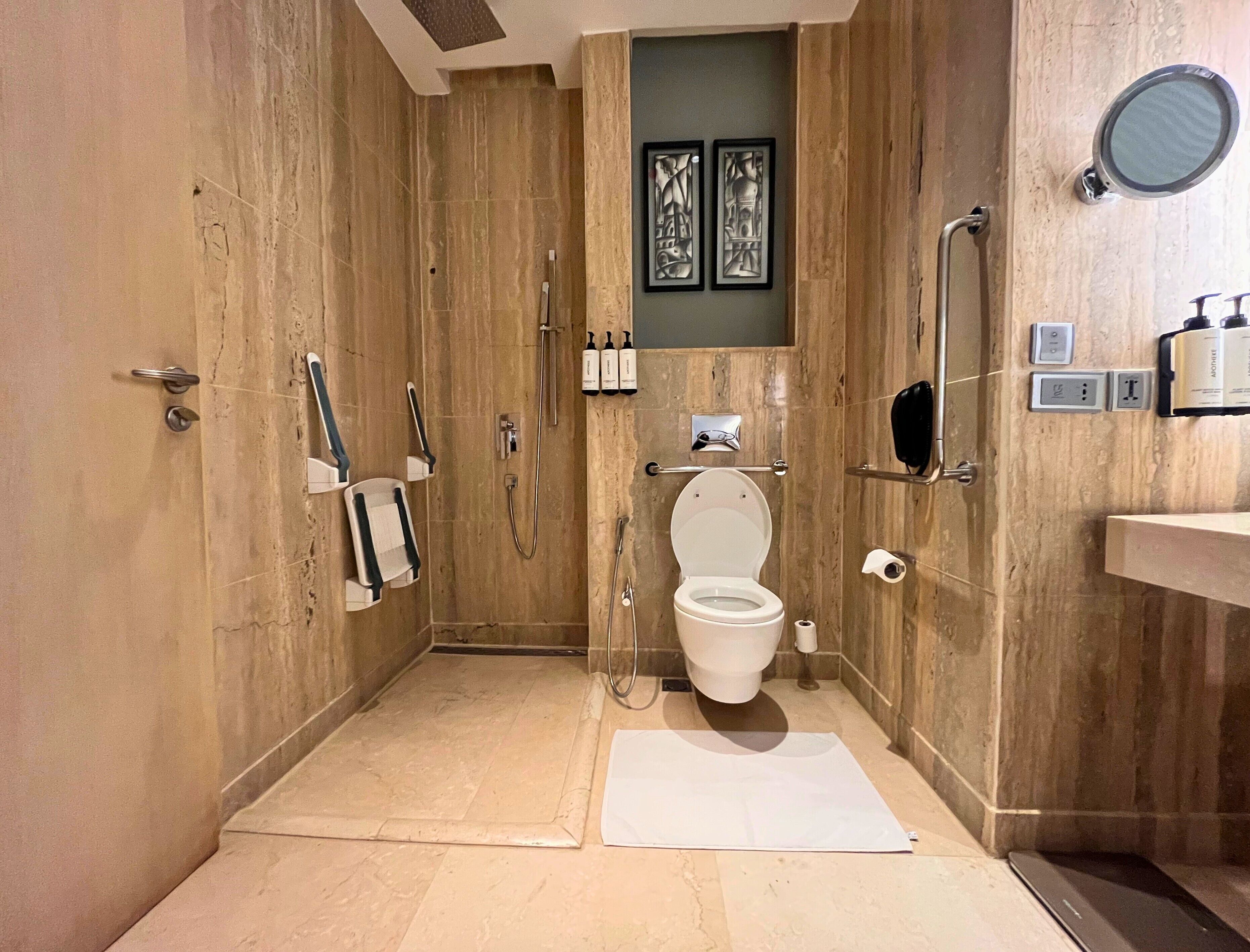 Un baño moderno con ducha a ras de suelo, inodoro y lavamanos.