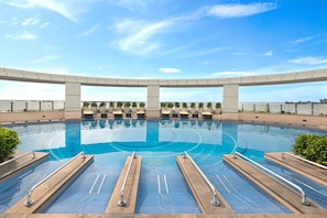 A large outdoor swimming pool with a clear blue sky above. - Crowne Plaza Greater Noida by IHG (Greater Noida)