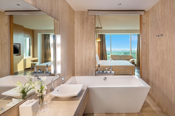 A modern bathroom with a large bathtub, a double sink, and a mirror. - Crowne Plaza Greater Noida by IHG (Greater Noida)