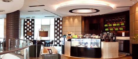 A modern interior with a central counter, seating area, and a decorative wall with geometric patterns.