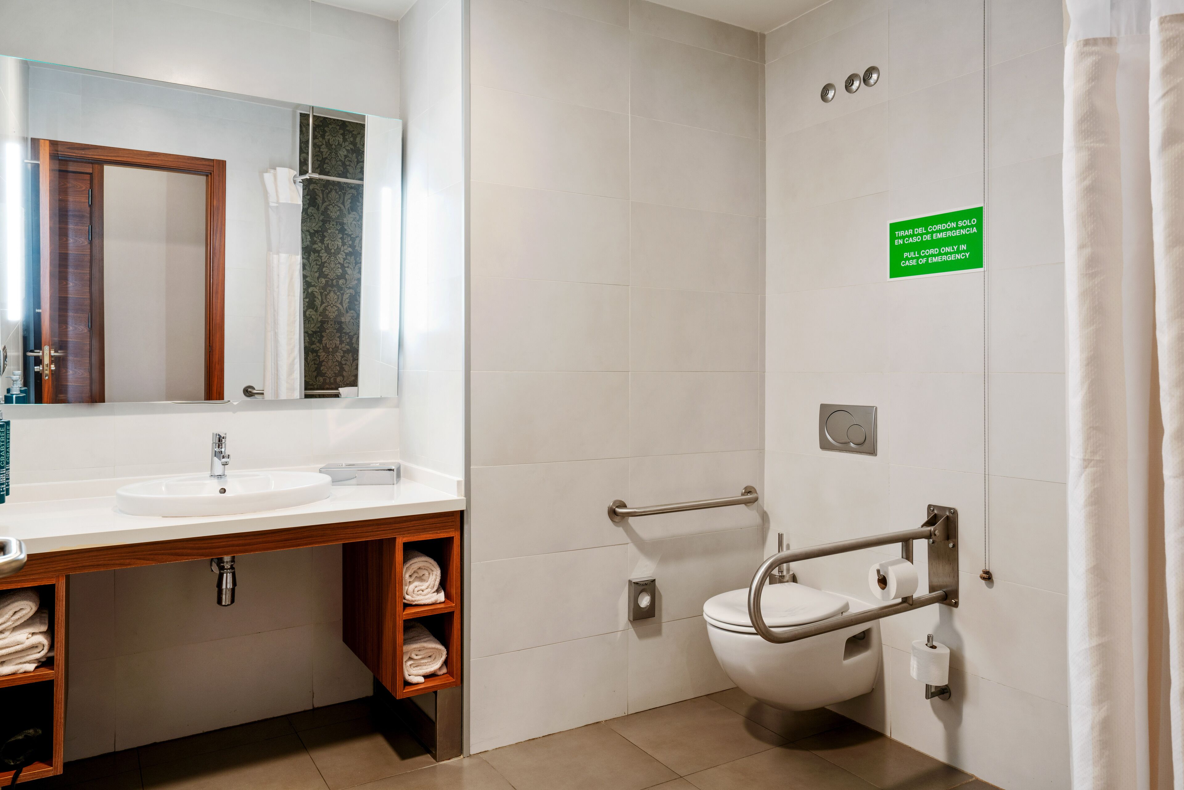 Une salle de bain moderne équip ée d’un lavabo, d’un miroir, de toilettes et d’une douche.