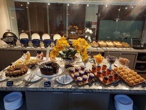 A buffet with various food items and a cake on display. - Golden Tulip Goiania Address (Goiania)