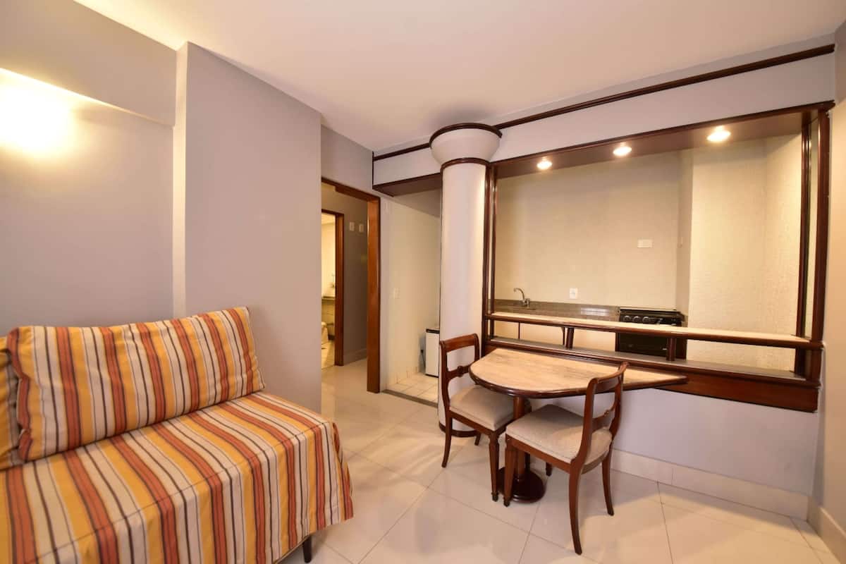Relax in this cozy living space with a sofa, dining table, and kitchen view.