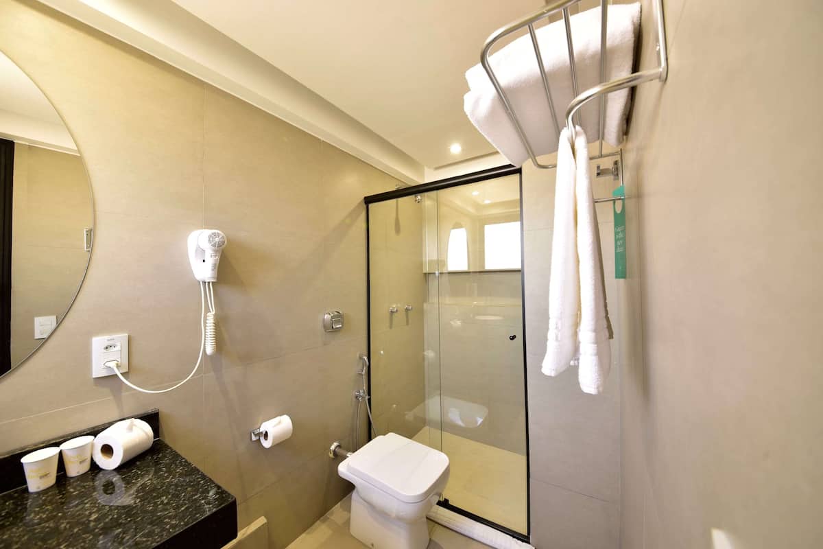 Enjoy a refreshing shower in the bathroom, featuring a hairdryer and a convenient toilet paper holder.