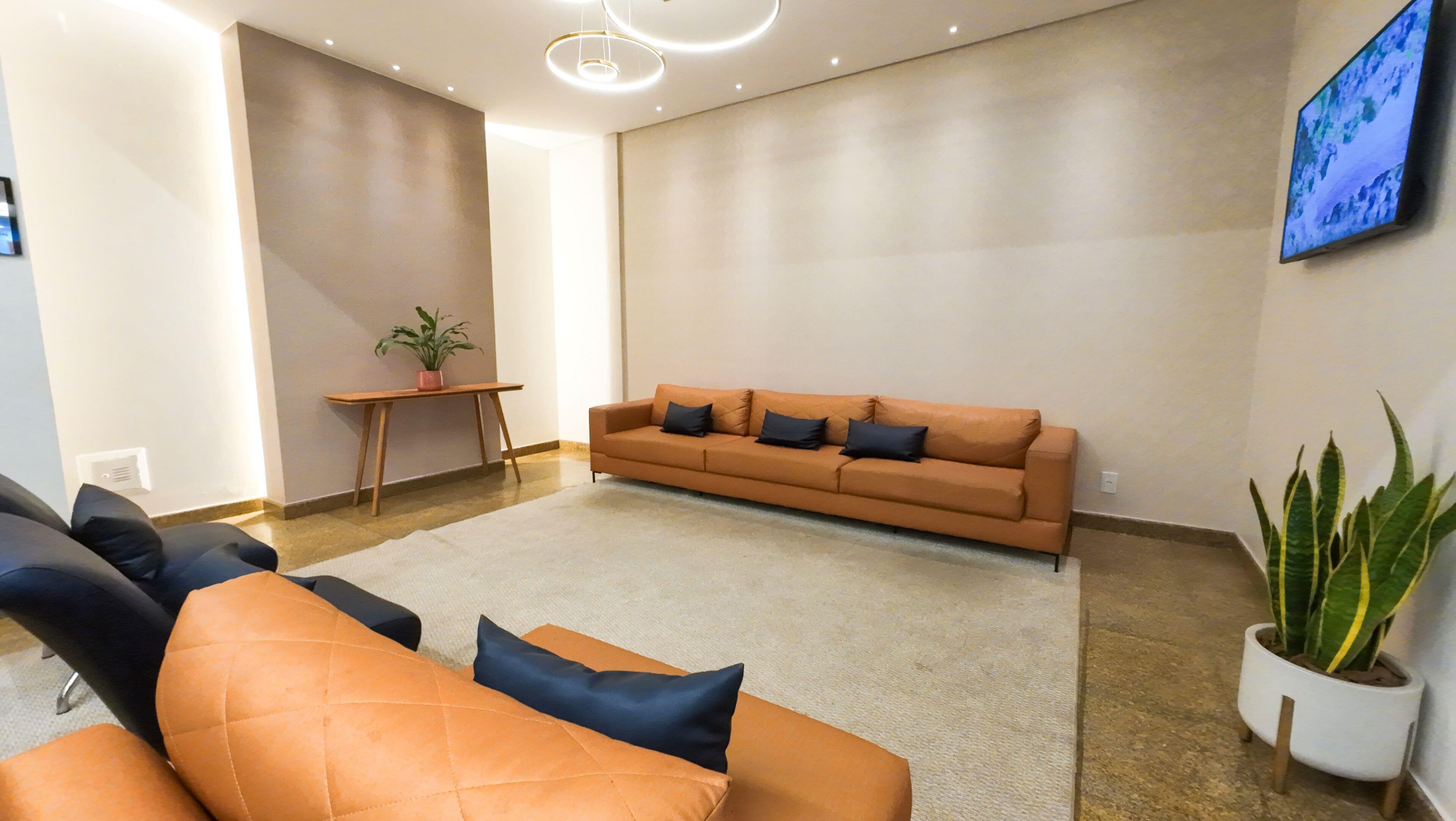 A modern living room with a sofa set, a coffee table, and a potted plant.
