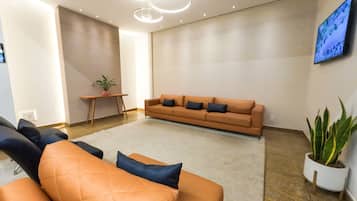 A modern living room with a sofa set, a coffee table, and a potted plant.