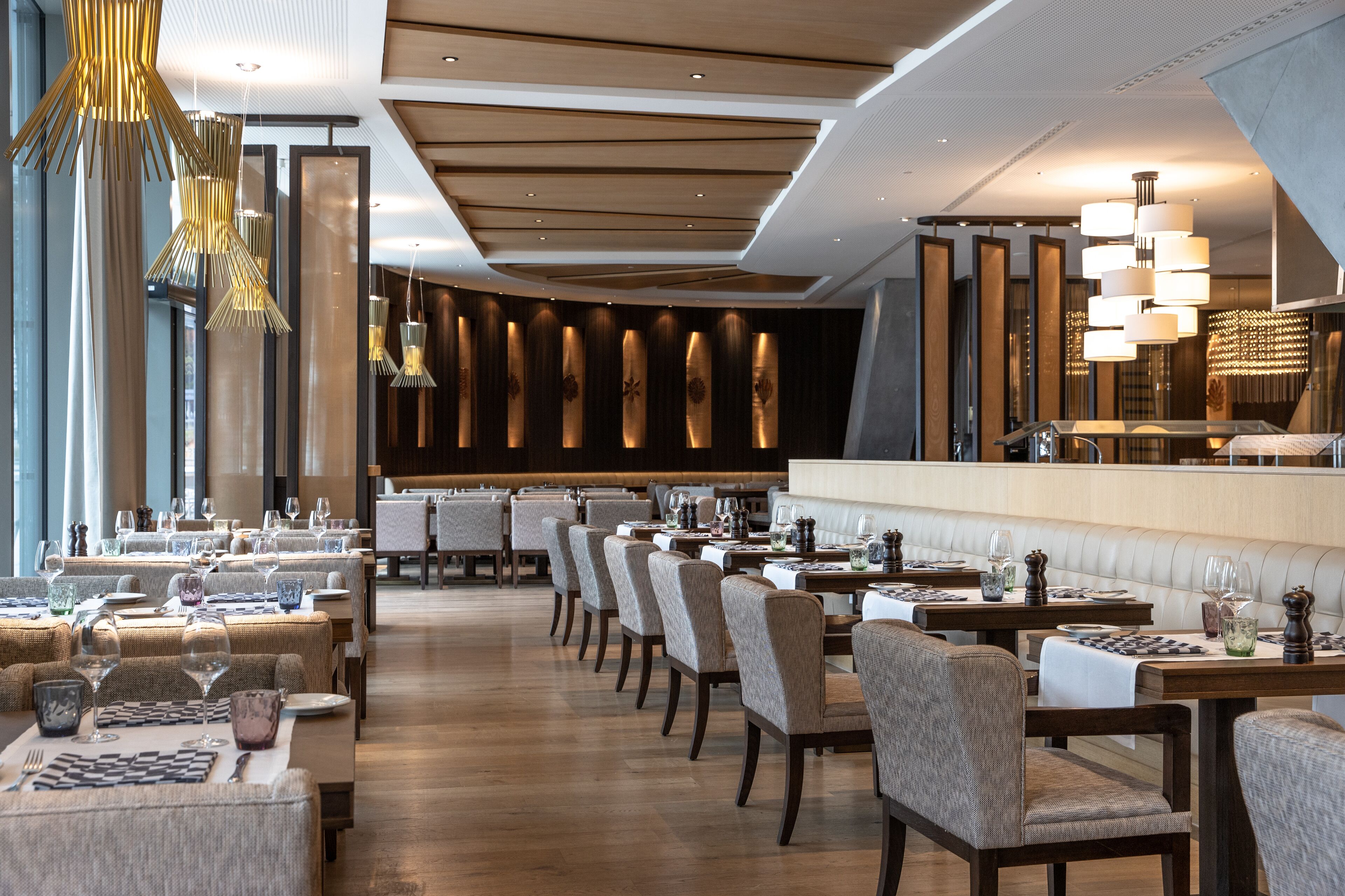 A restaurant with multiple dining tables, chairs, and a bar area.