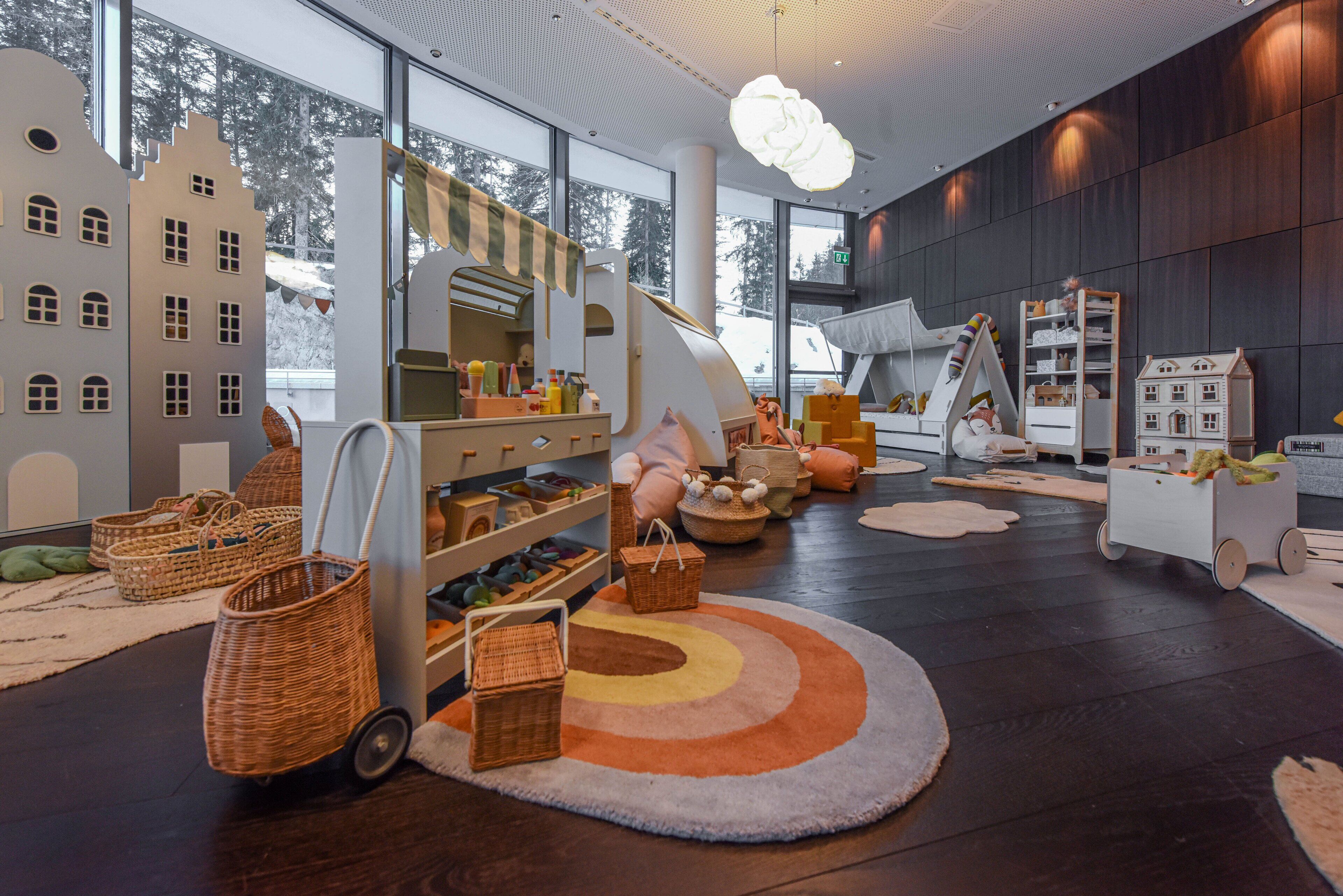 A play area with a large window, play structures, and storage baskets.