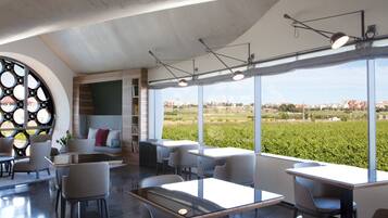 Un interior moderno con zona de estar, ventanas amplias y vistas al campo.