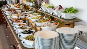 Un buffet proposant une variété de plats et agrémenté d’une statue décorative.