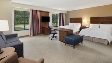Une chambre d’hôtel équipée d’un lit, d’un bureau, d’une chaise et offrant une vue sur l’extérieur.