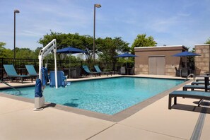 A swimming pool with lounge chairs and umbrellas, surrounded by a fence and trees. - Hampton Inn & Suites Huntsville/Research Park Area (Huntsville)