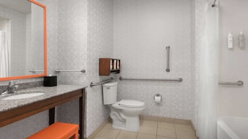 A bathroom with a toilet, sink, and mirror.