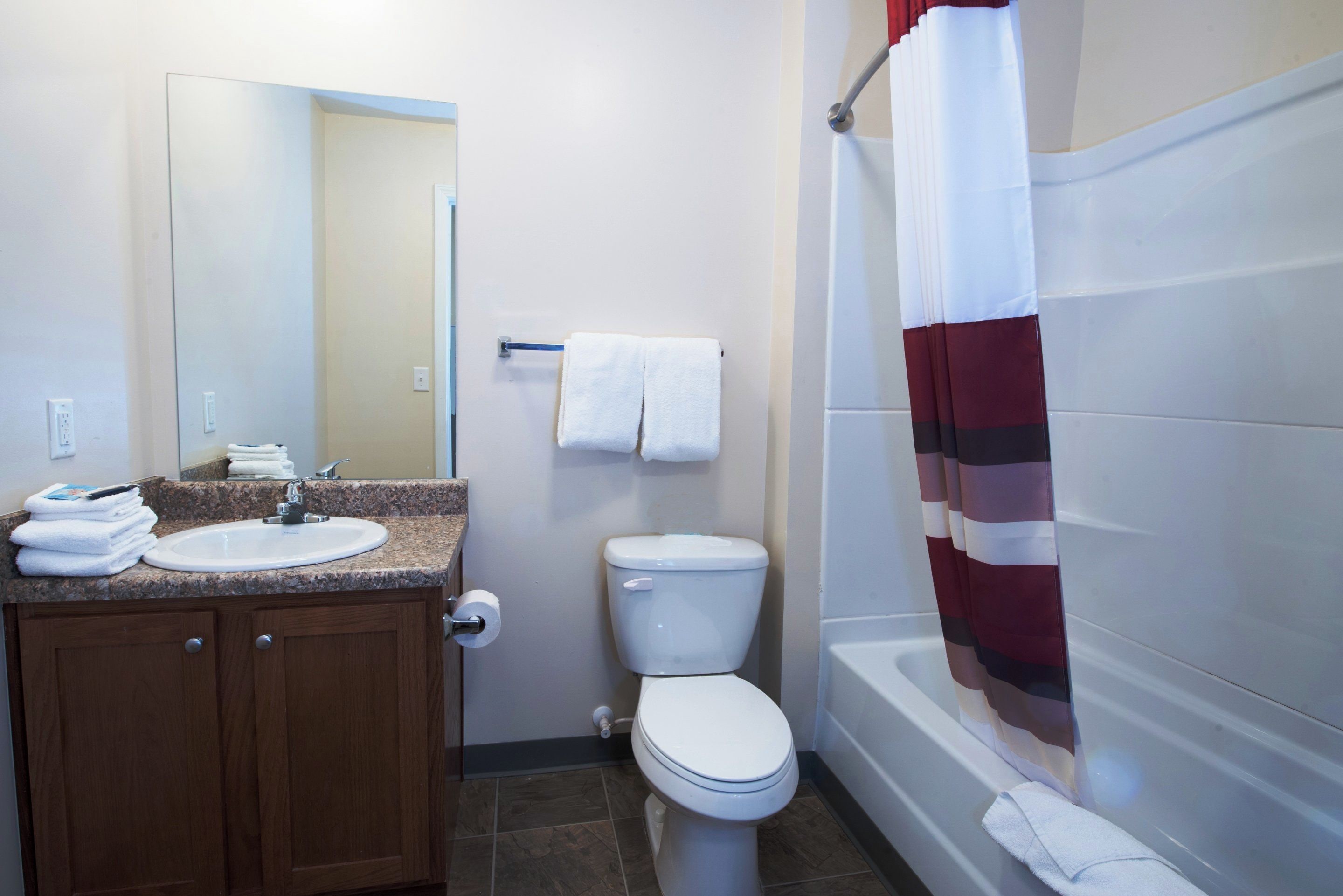 Une salle de bain avec un lavabo, des toilettes et un rideau de douche.