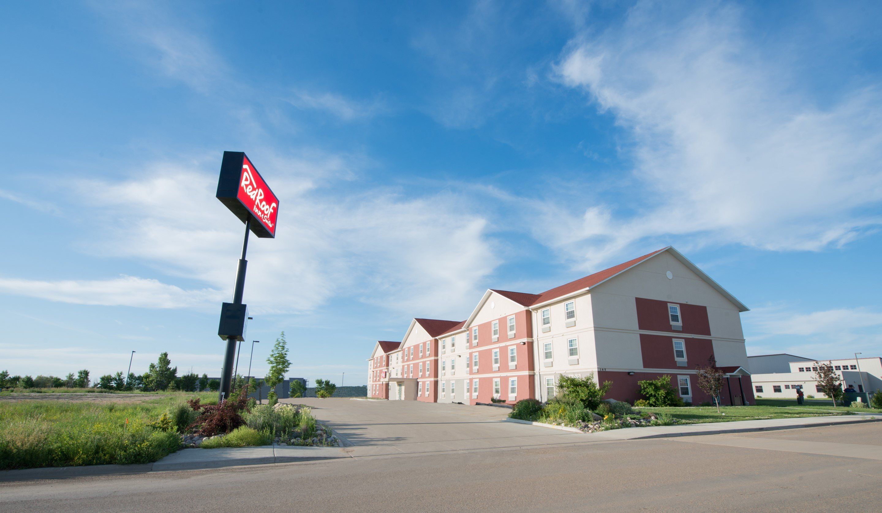 Et RedRoof Inn & Suites hotel med blå himmel.