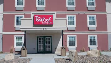 A RedRoof Inn & Suites building with a red facade, white trim, and a number '165' displayed above the entrance.