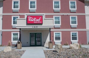 Edificio RedRoof Inn & Suites con fachada roja, detalles blancos y el número '165' exhibido sobre la entrada.