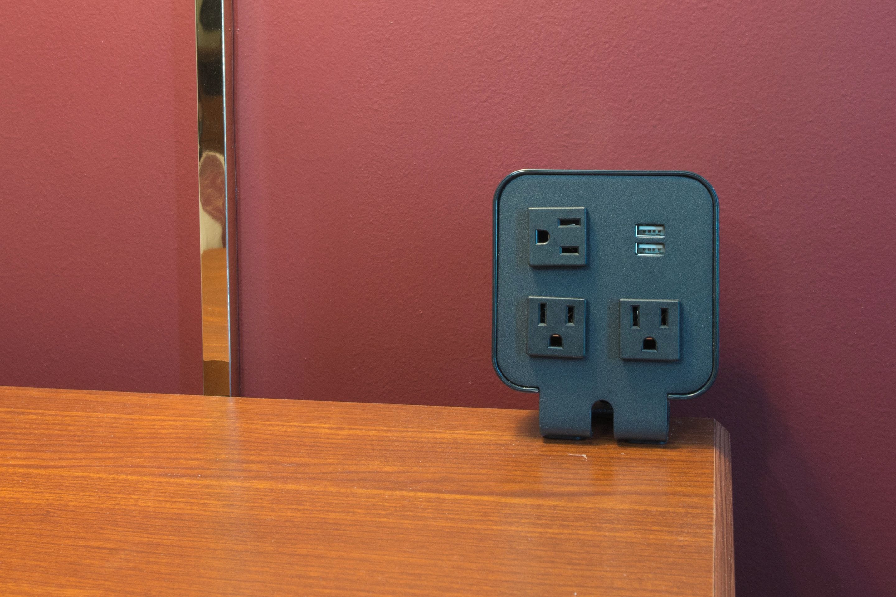 A wall-mounted power strip with two standard electrical outlets and a USB port.