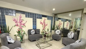 A modern living room with grey sofas, a glass coffee table, and decorative plants. - Casa Fanning Apart Hotel (Lima)