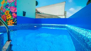 A swimming pool with blue tiles and a colorful flower mural on the wall. - Casa Fanning Apart Hotel (Lima)
