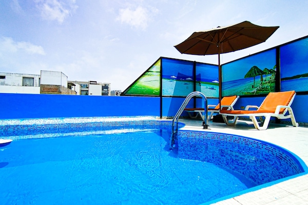 Una piscina al aire libre de temporada, sillones reclinables de piscina