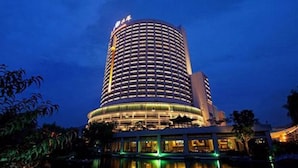 A multi-story hotel with a circular design, featuring a pool in front. - Shandong Hotel (Jinan)