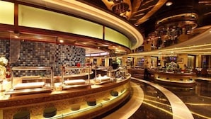 A modern hotel lobby with a curved reception desk, a seating area, and a decorative wall. - Shandong Hotel (Jinan)